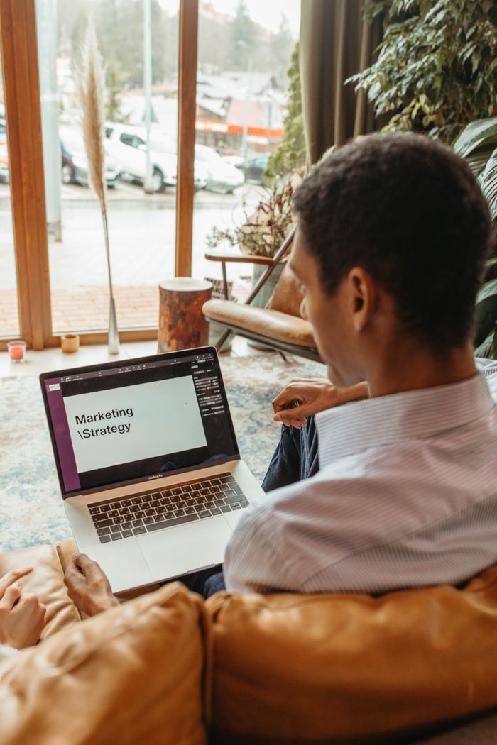 our-story A man reviews a marketing strategy on his laptop in a cozy indoor setting.