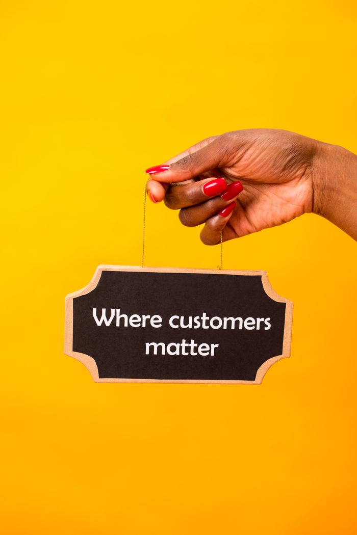 who-we-are Hand holding a sign with 'Where customers matter' on a vibrant yellow backdrop.